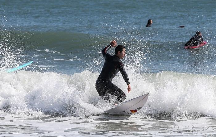 한 서퍼가 서핑 명소 부산 송정앞바다에서 균형을 잡고 있는 모습.jpg